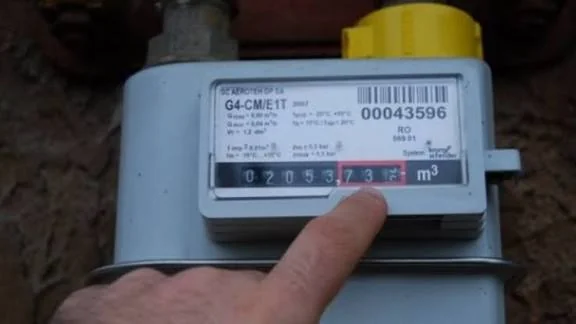 Deget arătând indexul afișat pe contorul de gaz pentru citirea consumului lunar