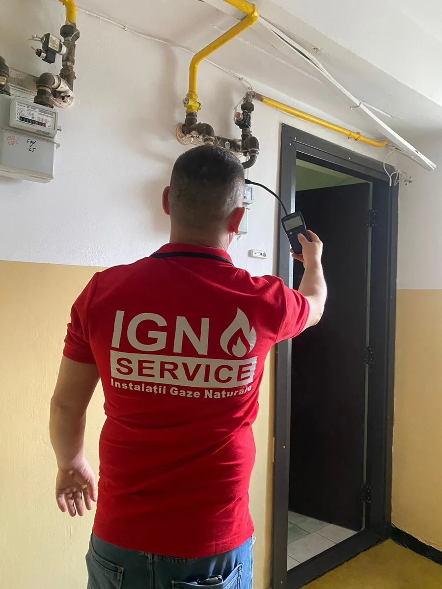 Tehnician IGN Service testează cu detector electronic instalația de gaz de lângă contorul din bloc