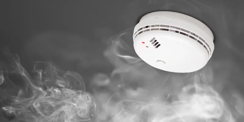 Detector monoxid carbon și fum rotund alb cu LED roșu pe fundal