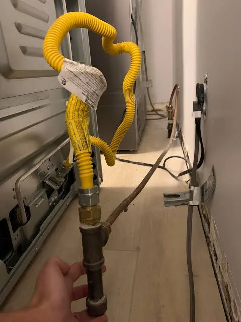 Furtun flexibil galben de gaz conectat la racordul din spatele aragazului, verificat manual