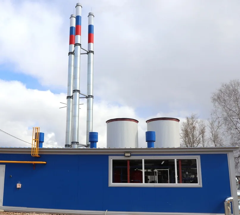 Centrală termică industrială albastră cu coșuri de fum și țeavă galbenă de gaz