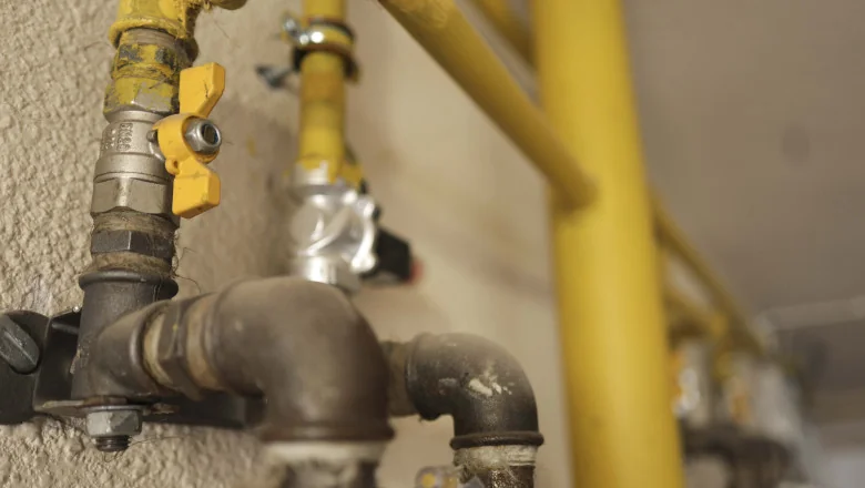 Instalator în geacă IGN Service verifică cu detectorul electronic un contor de gaz pe casa scării, Botoșani