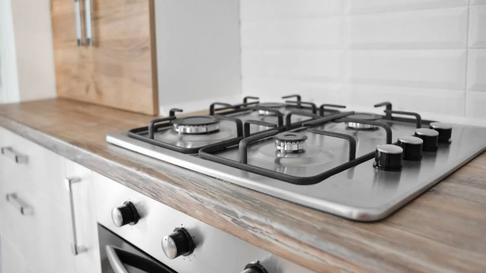 Plită pe gaz încorporabilă din inox cu patru arzătoare, montată într-un blat de bucătărie