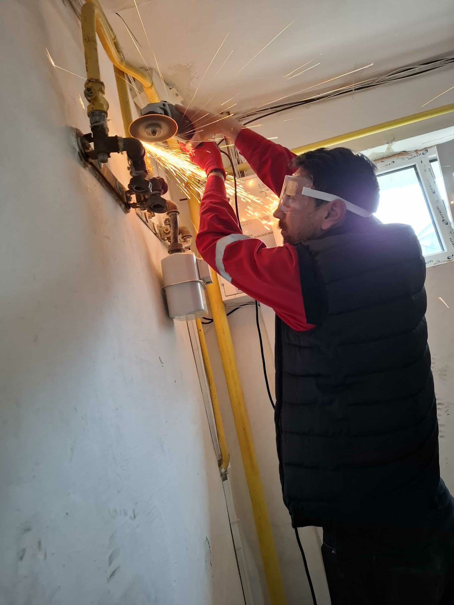 Tehnician IGN Service taie țeavă de gaz cu polizor unghiular, lângă contor, interior