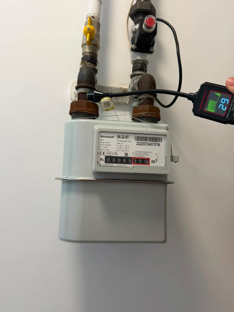 Tehnician IGN Service întinde cu peria spumă de săpun pe racordul contorului de gaz, Iași